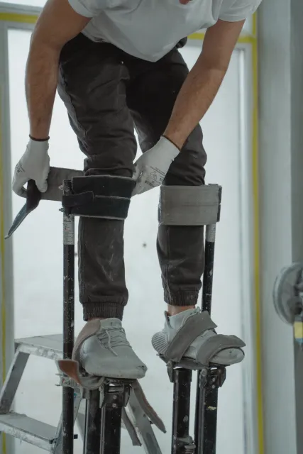 Stock reference: a worker preparing interior walls during renovation.