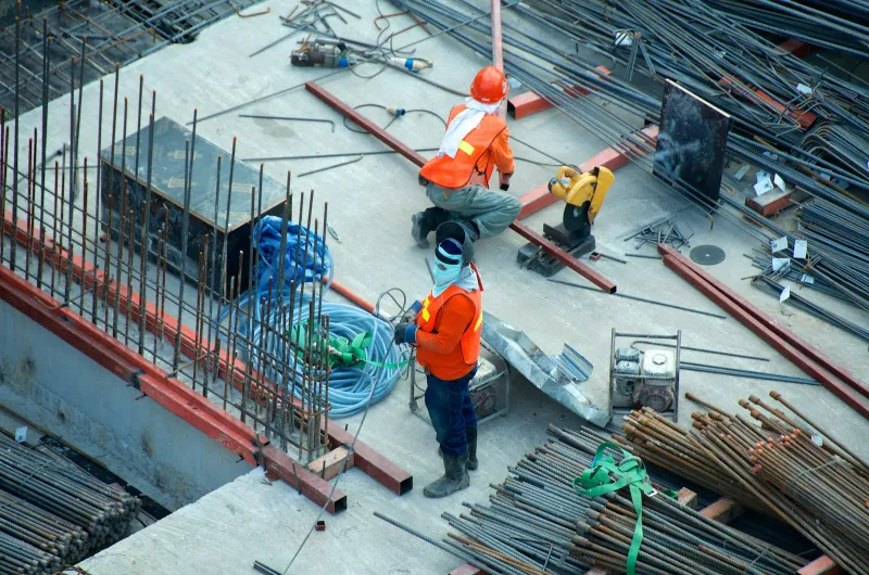 Stock reference: construction workers and structural reinforcement on a building site.