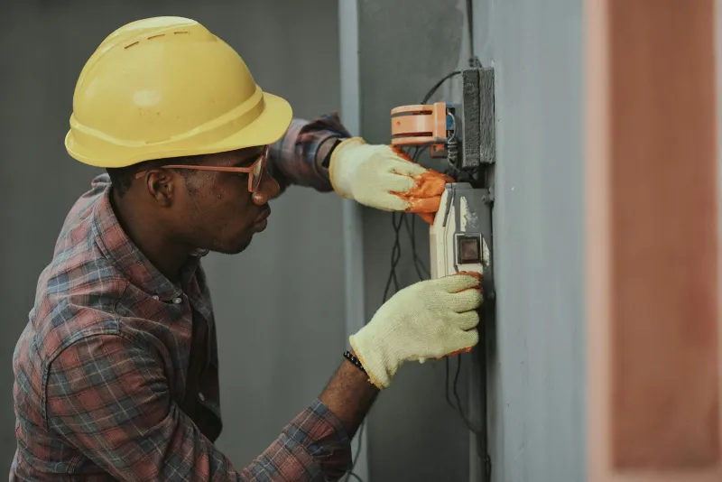 Stock reference: an electrical worker checking installation alignment.